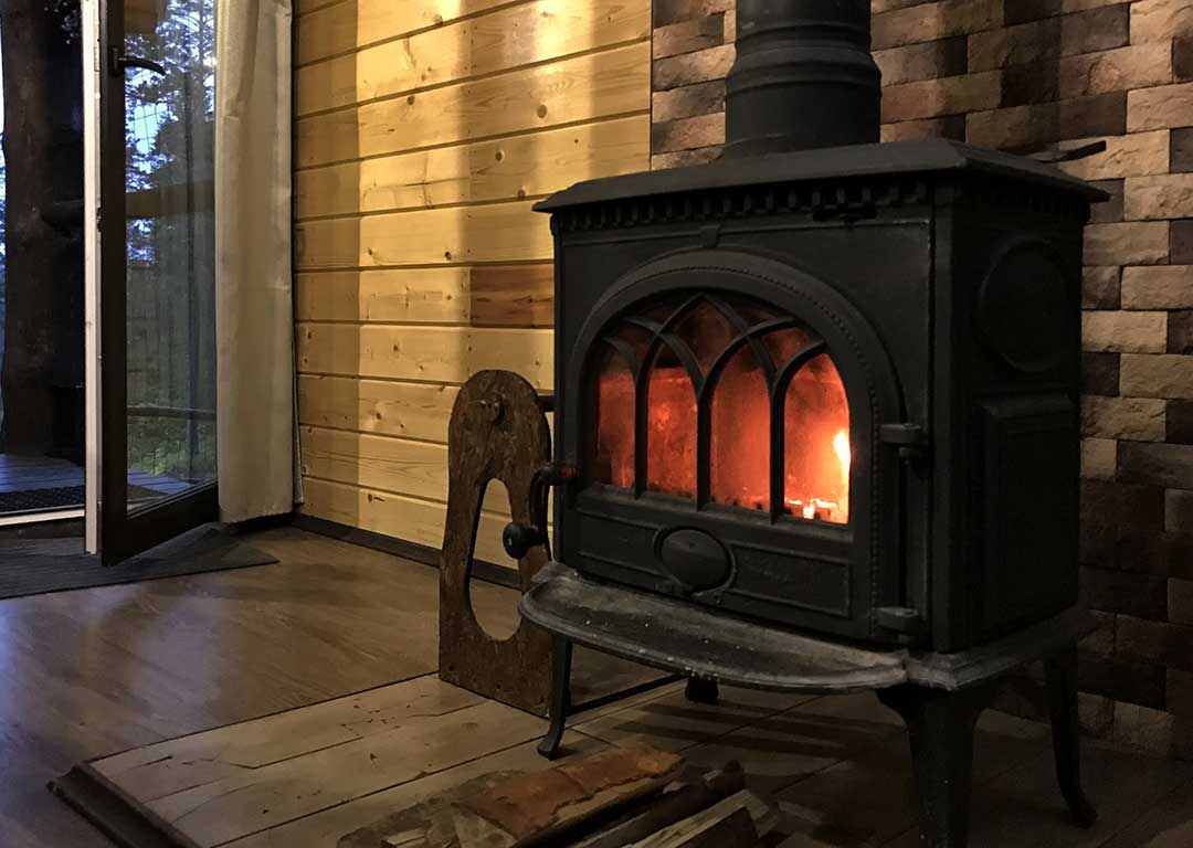 Wood stove in traditional brick fireplace