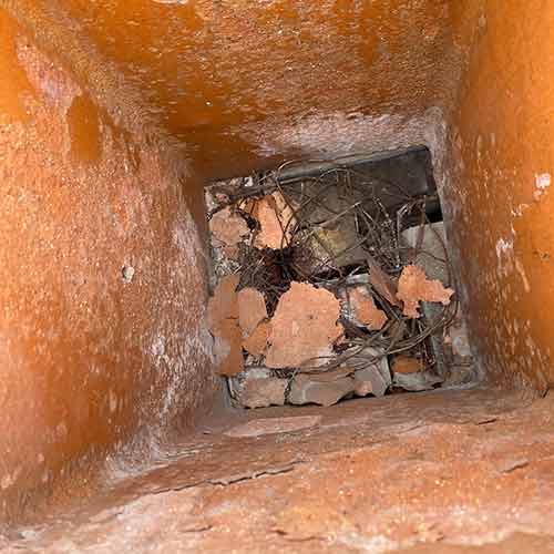 Blocked Chimney Flue Caused by debris because there's not a cap on this chimney