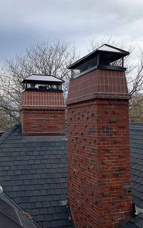 Two Brick Chimneys Black Steel Caps