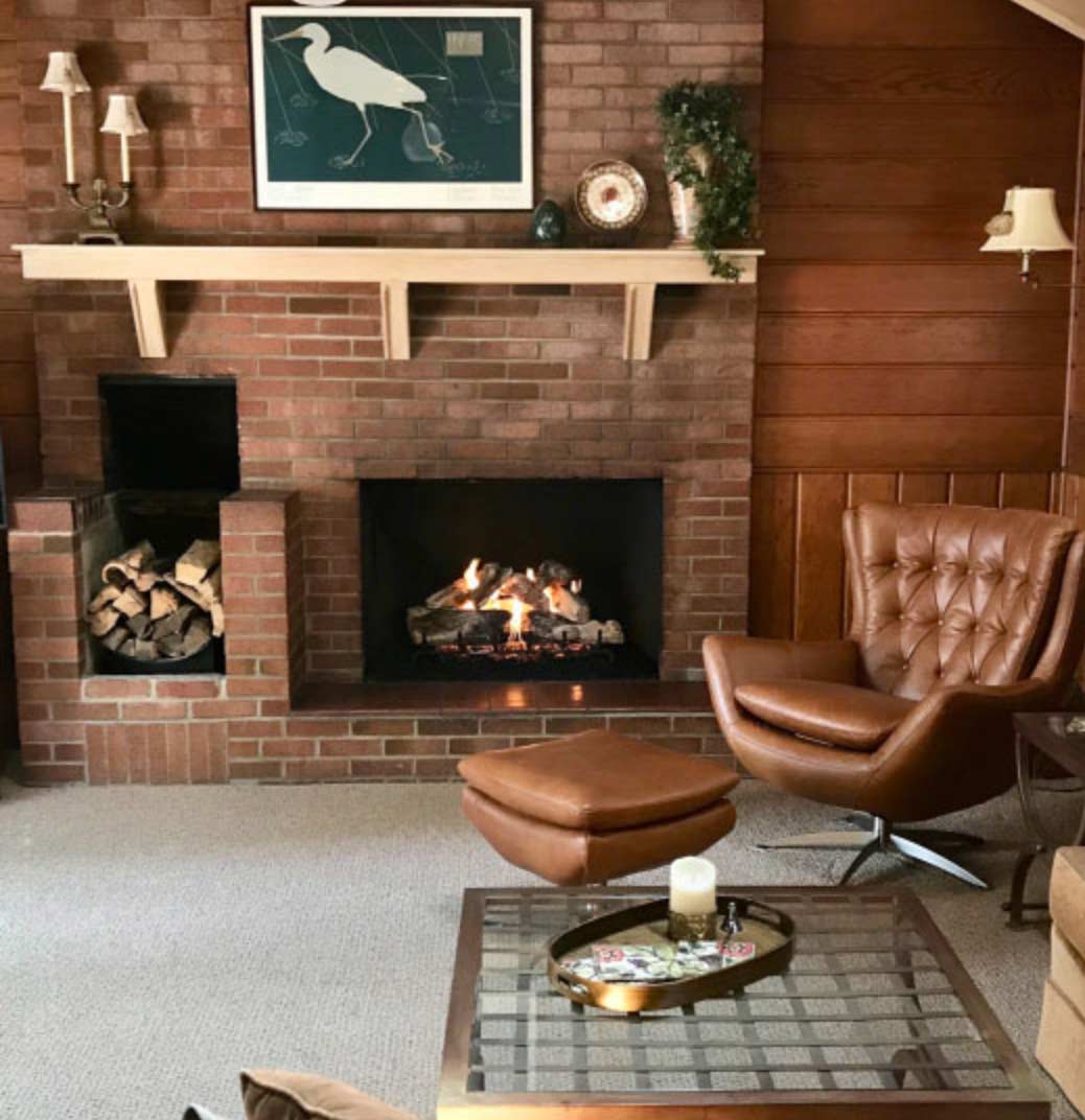 firewood stack sits next to brick fireplace hearth