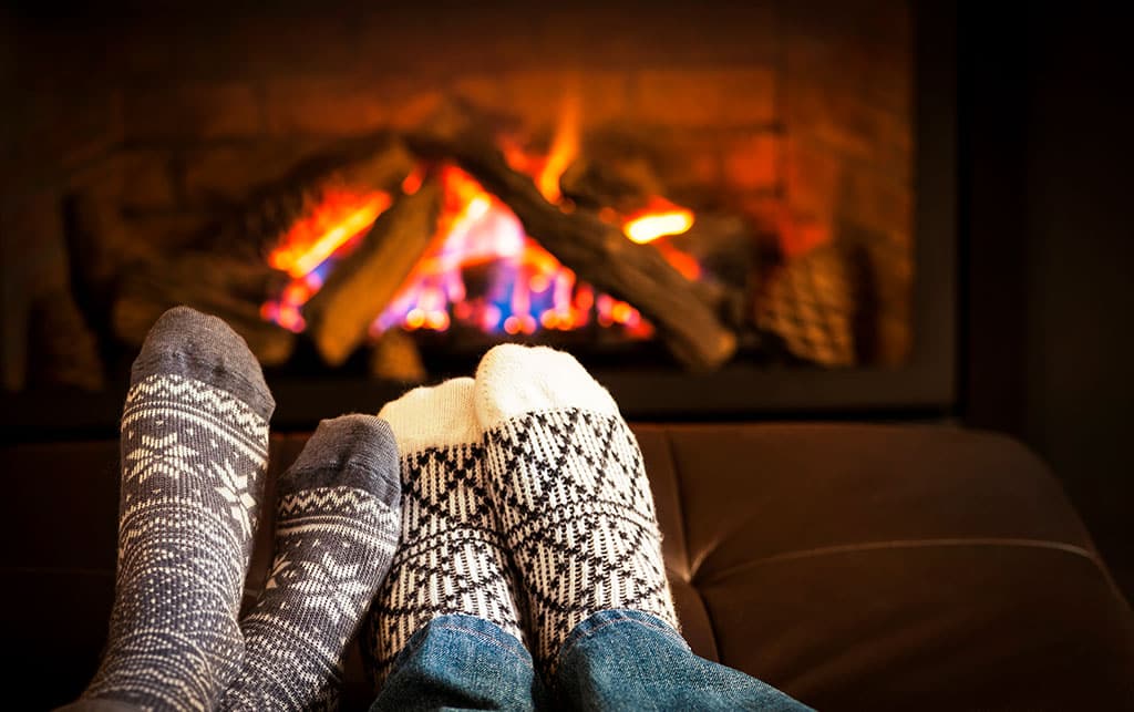 Feet warming by fireplace