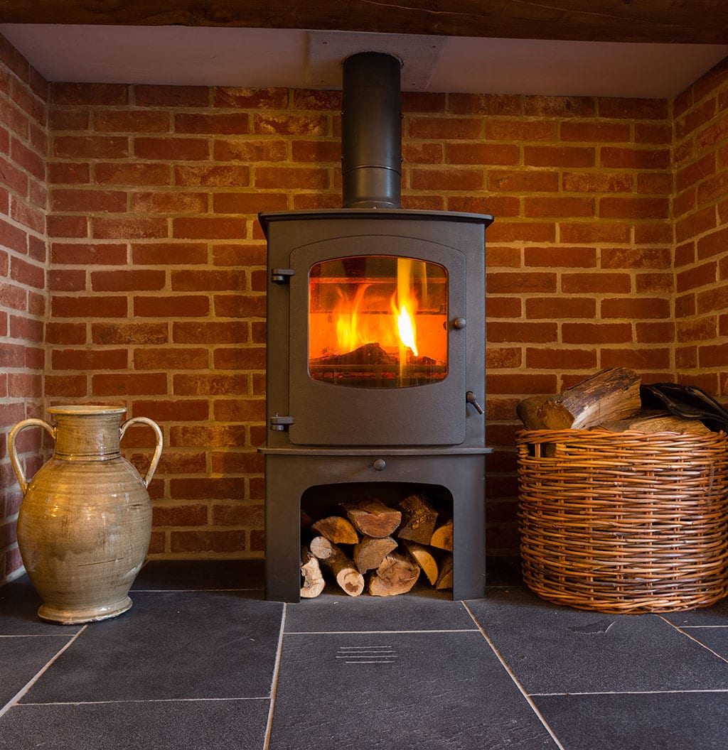 Wood burning stove in brick fireplace