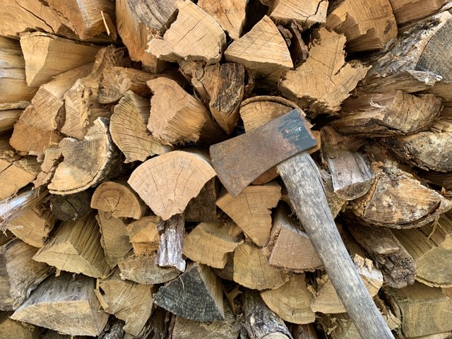 pile of wood logs with axe