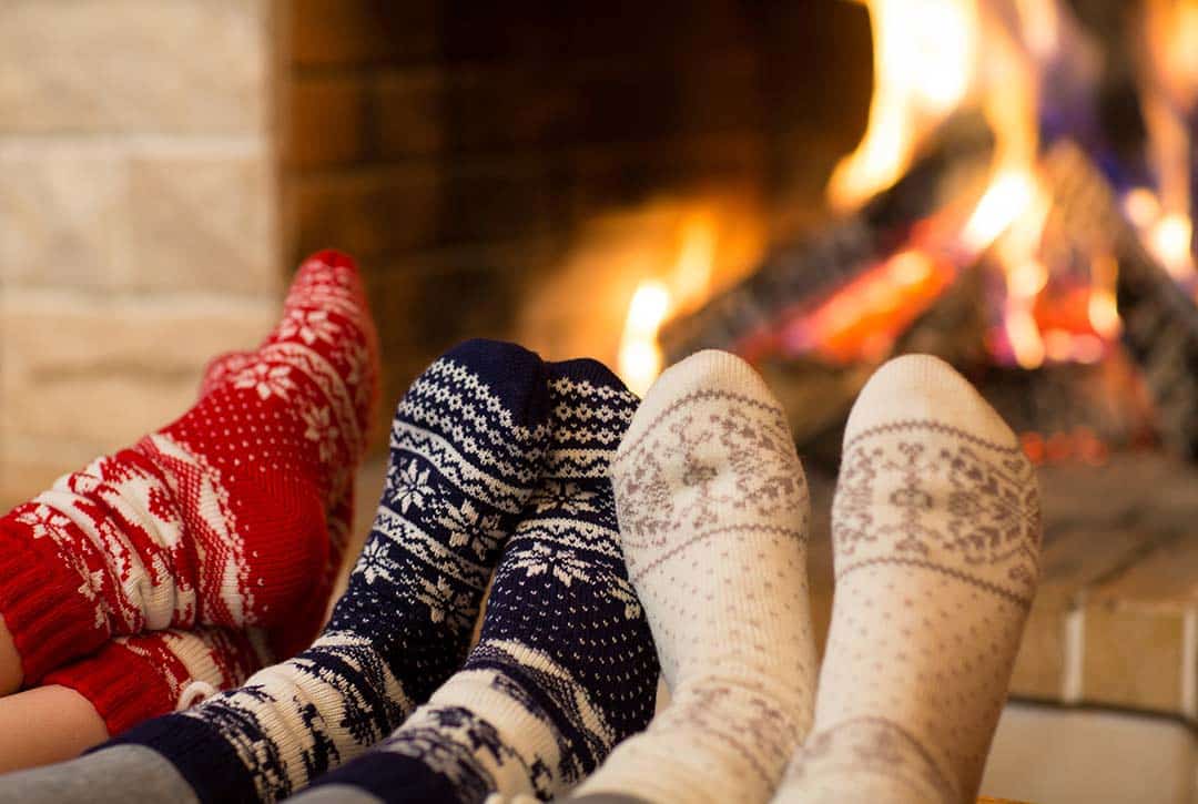 People in Winter Socks Enjoying Wood Fireplace Burning Flames