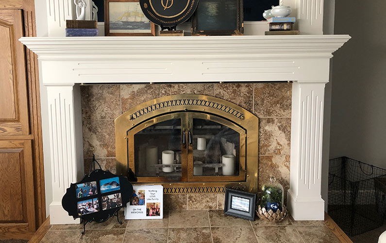 Gold Glass Doors on a White Mantel Fireplace with Candles 