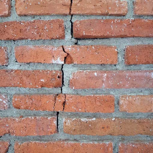 Crack spreading down a brick chimney.