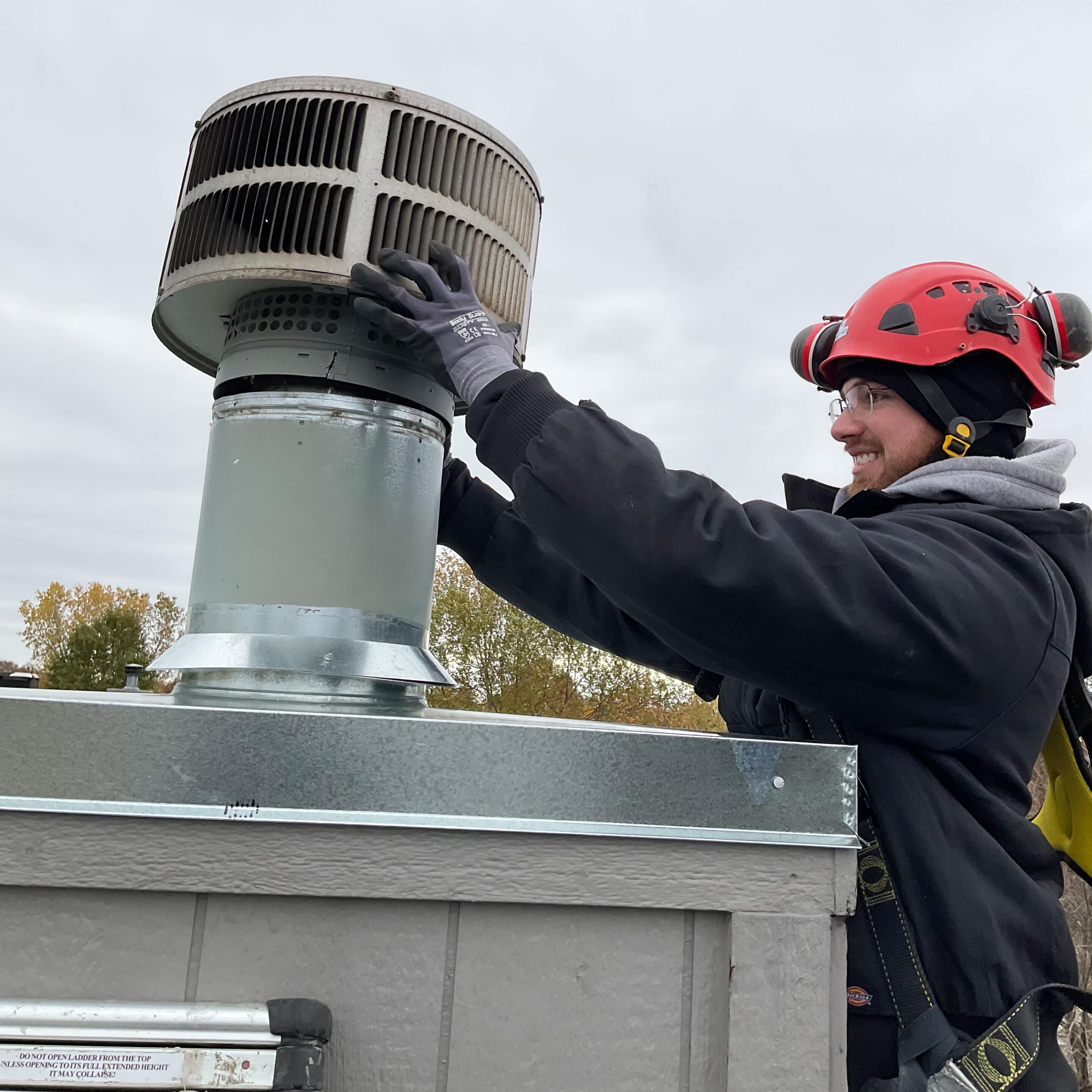 tech installs prefab chimney chase cover with storm guard and termination cap