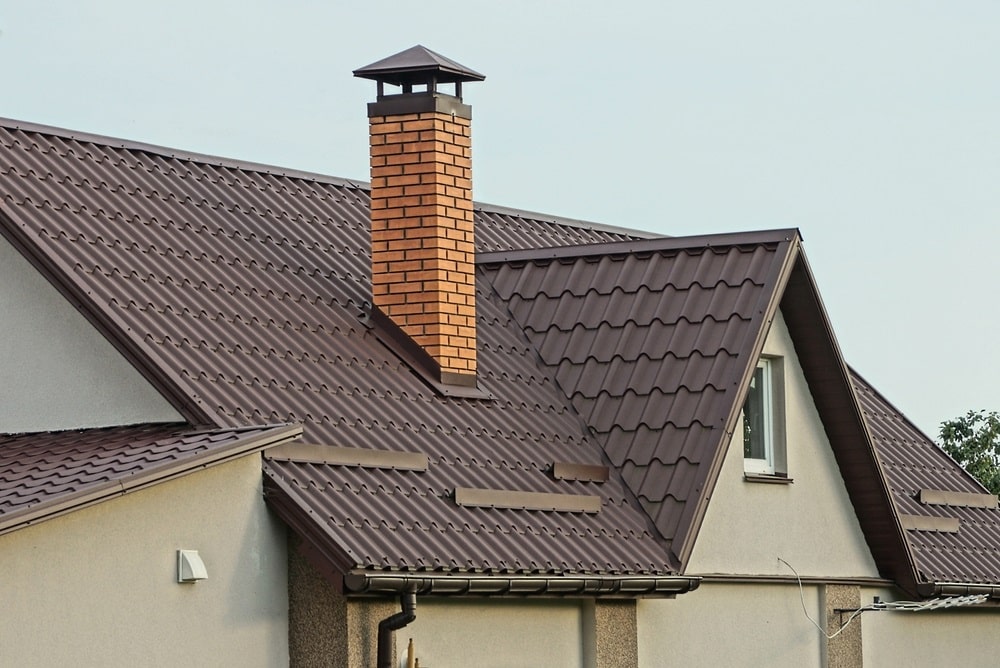 brick chimney on a brown tiled roof brick chimney on a brown tiled roof