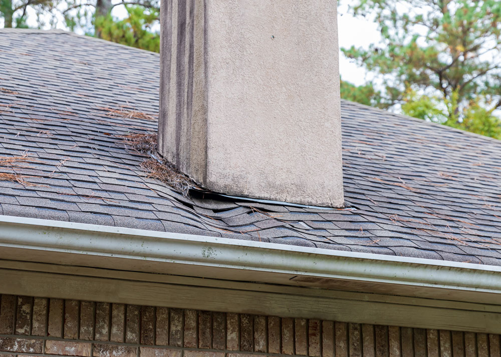 roof needing repair from damage caused be water leak around chimney